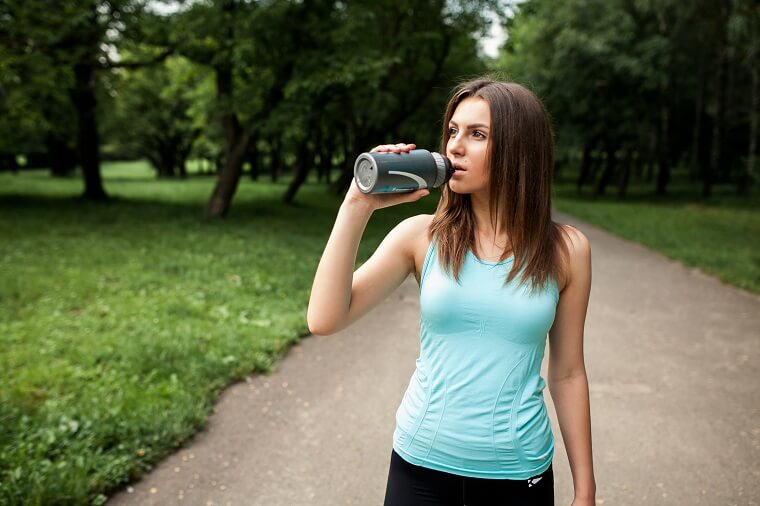Sportswoman park drinking water bottle
