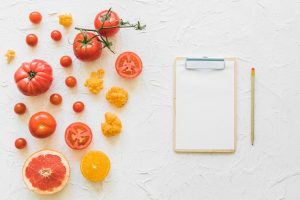 White paper clipboard with pencil vegetables textured backdrop