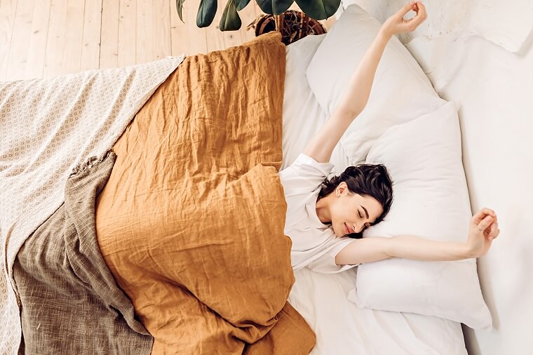 Woman lying on bed with blankets